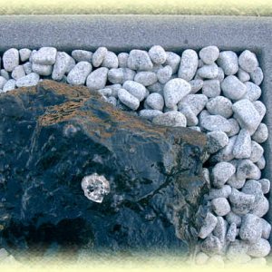 Basalt-Quellstein       auf hellgrauem Zierkies in Basalt-Becken 